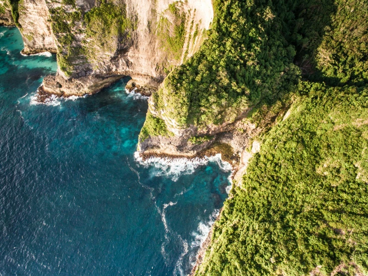 a cliff in the middle of a body of water, bali, overhead birdseye view, new zealand, slide show