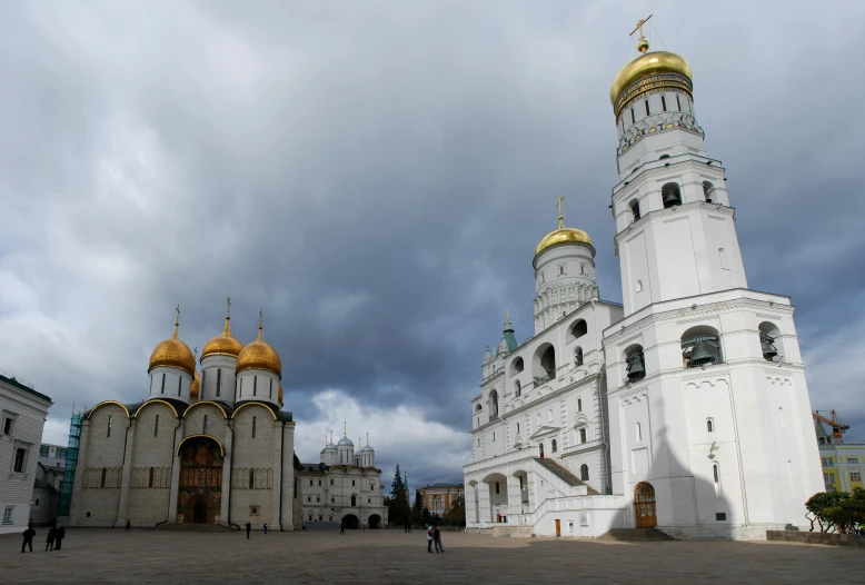 a large white building with gold domes under a cloudy sky, an album cover, inspired by Vasily Surikov, unsplash, socialist realism, square, photograph credit: ap, elegant walkways between towers, reuters