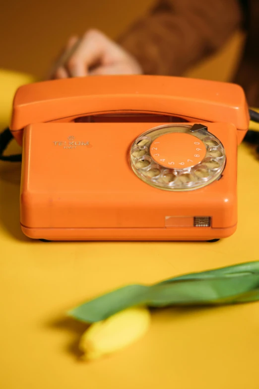 an orange telephone sitting on top of a yellow table, 🎀 🍓 🧚, profile pic, promo image, vintage