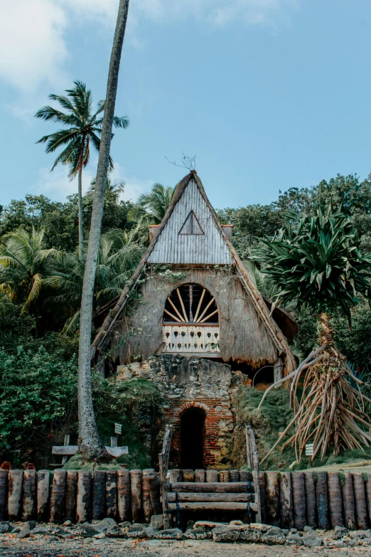 a house sitting on top of a lush green hillside, an album cover, unsplash, renaissance, samoan features, sacred architecture, wedding, tropics