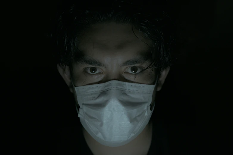 a man wearing a face mask in the dark, an album cover, pexels contest winner, hyperrealism, japanese live-action movie, healthcare, video still, 8 k movie still