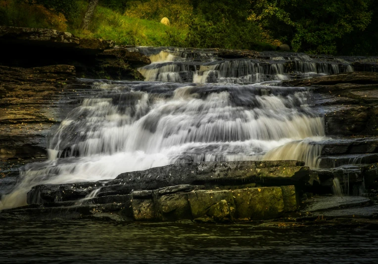 a waterfall in the middle of a lush green forest, pexels contest winner, hurufiyya, sandfalls, sitting near a river, yorkshire, thumbnail