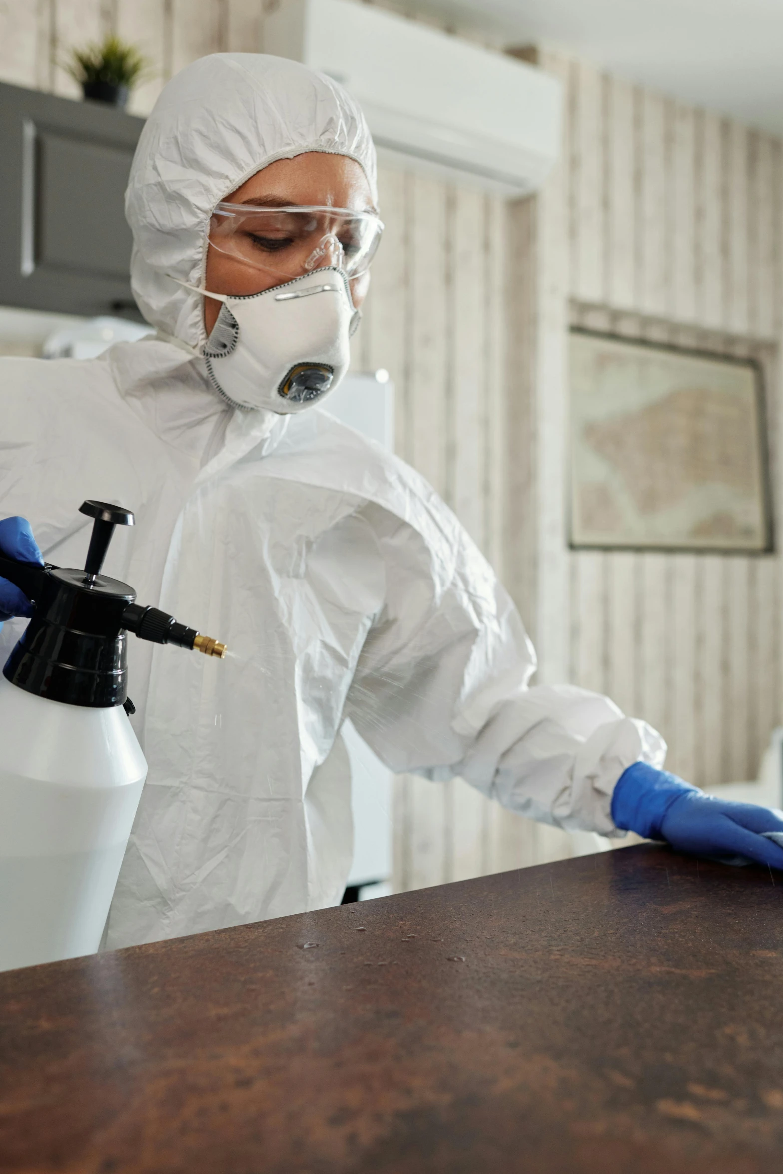 a man in a hazmat suit sprays down a table, a portrait, shutterstock, brown, 4l, domestic, wearing lab coat and a blouse
