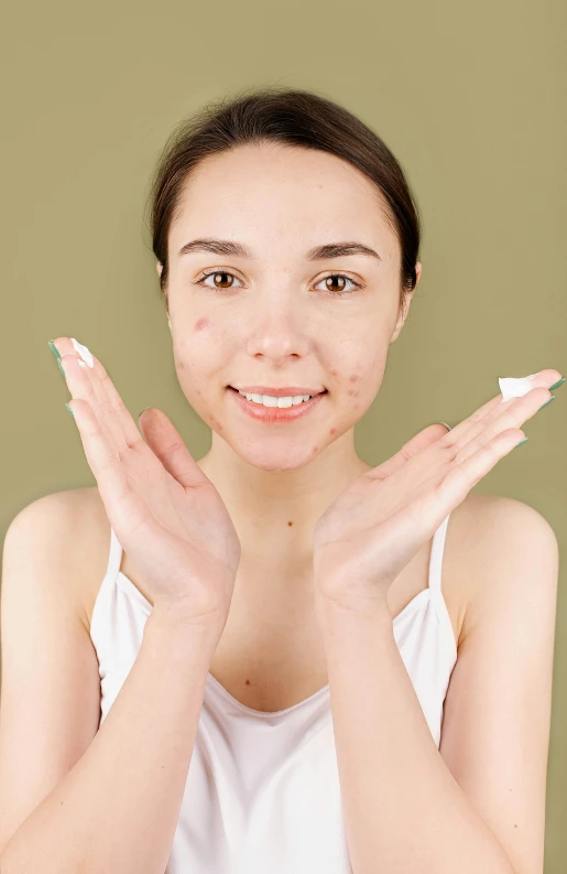 a woman holding her hands up in front of her face, surface blemishes, promo image, foam, scar on the cheek