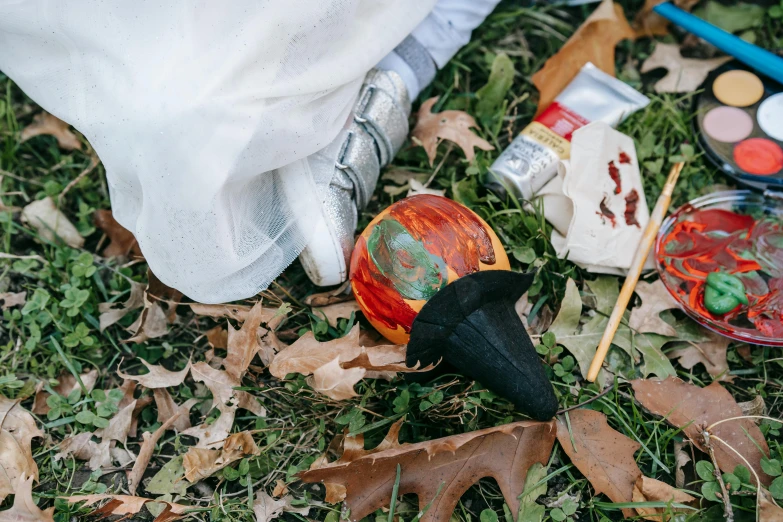 a person standing on top of a lush green field, an album cover, by Julia Pishtar, pexels contest winner, process art, holding a jack - o - lantern, tools and junk on the ground, papier - mache, hibernation capsule close-up