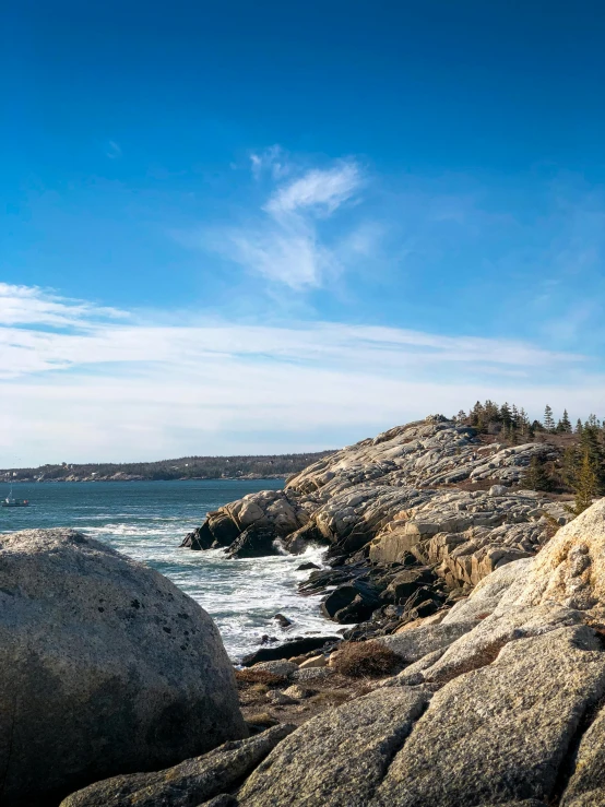 a man standing on top of a rock next to the ocean, slide show, maple syrup sea, profile image