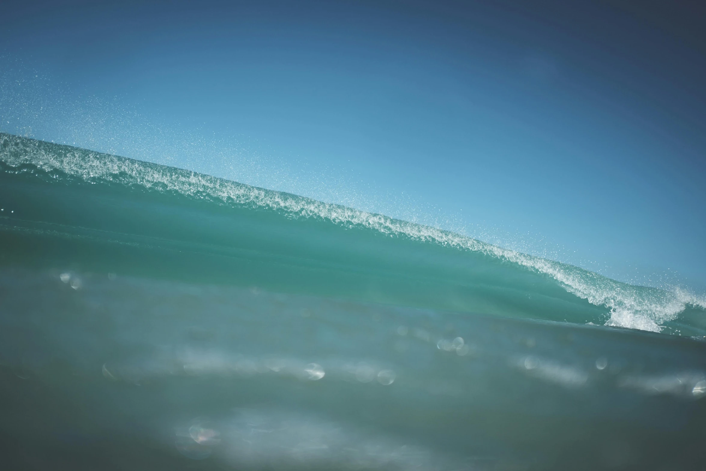 a man riding a wave on top of a surfboard, an album cover, unsplash contest winner, hurufiyya, glistening seafoam, australian beach, cerulean blue, water particules