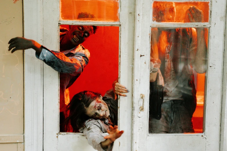 a couple of people that are looking out of a window, zombies attack, in doors, in australia, halloween decorations