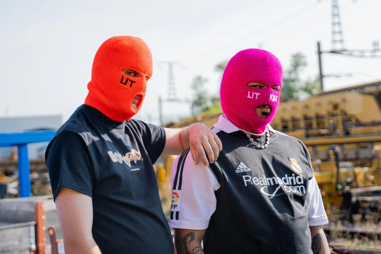 a couple of men standing next to each other, an album cover, unsplash, lyco art, orange balaclava, portrait of a pink gang, football, luts