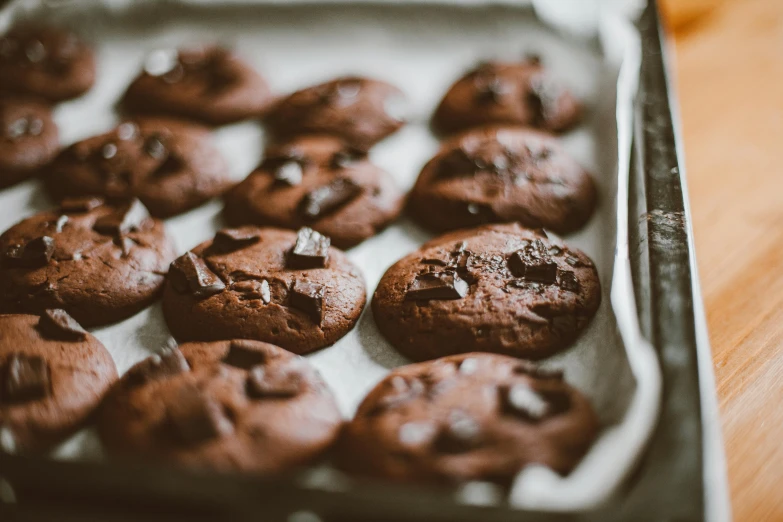 a pan filled with chocolate cookies on top of a wooden table, by Emma Andijewska, trending on pexels, 🦩🪐🐞👩🏻🦳, oven, 6 pack, brunettes