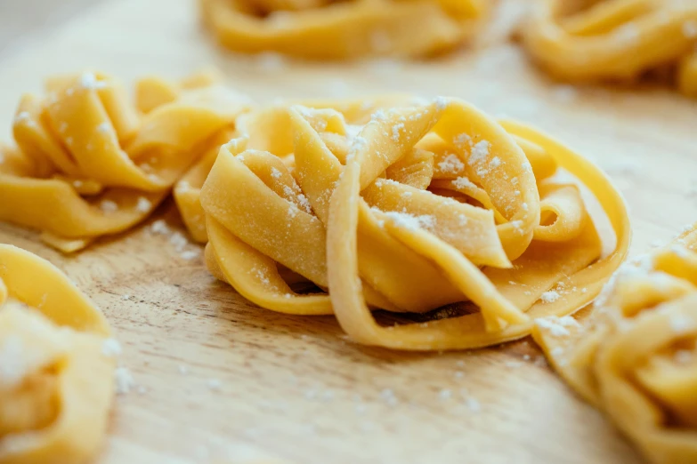 a bunch of pasta sitting on top of a wooden cutting board, filippo brunelleschi, wrinkles, dessert, loosely cropped