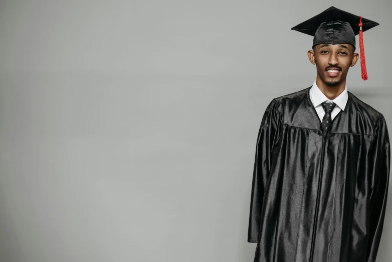 a man in a graduation cap and gown, pexels, black leather garment, black man, on a gray background, schools