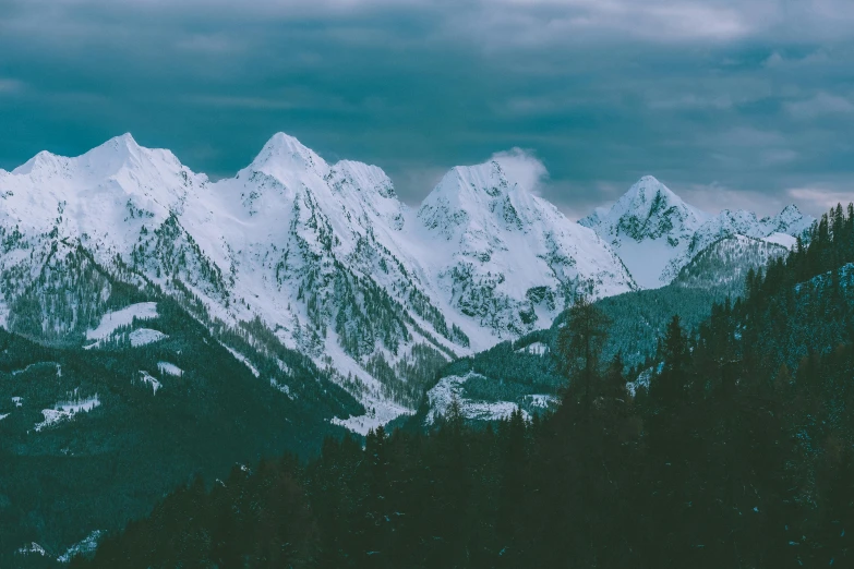 a snow covered mountain range under a cloudy sky, pexels contest winner, teal aesthetic, thumbnail, multiple stories, evergreen valley