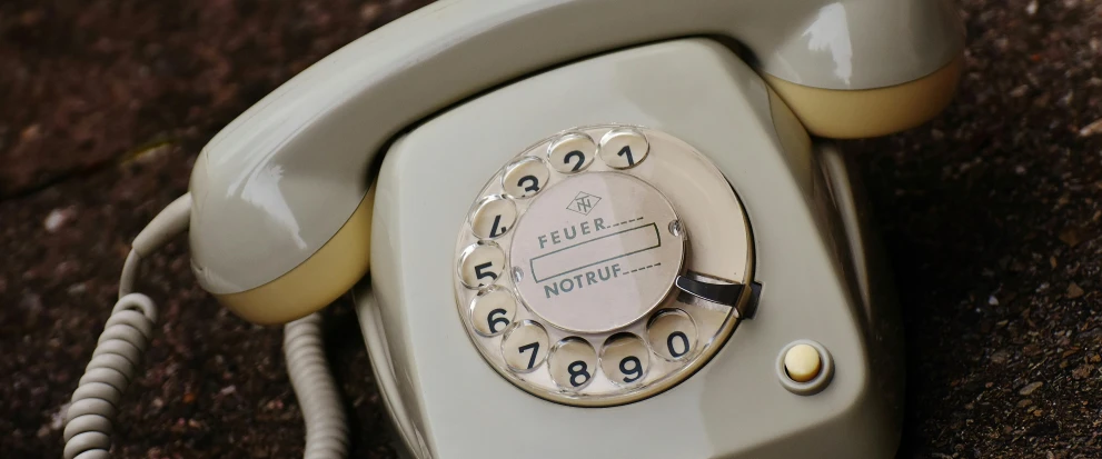 a close up of a telephone on the ground, inspired by Fritz Baumann, unsplash, art nouveau, silver，ivory, grey