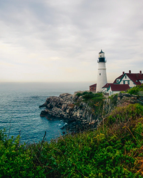 a lighthouse sitting on top of a cliff next to the ocean, listing image, new england architecture, multiple stories, cute photo