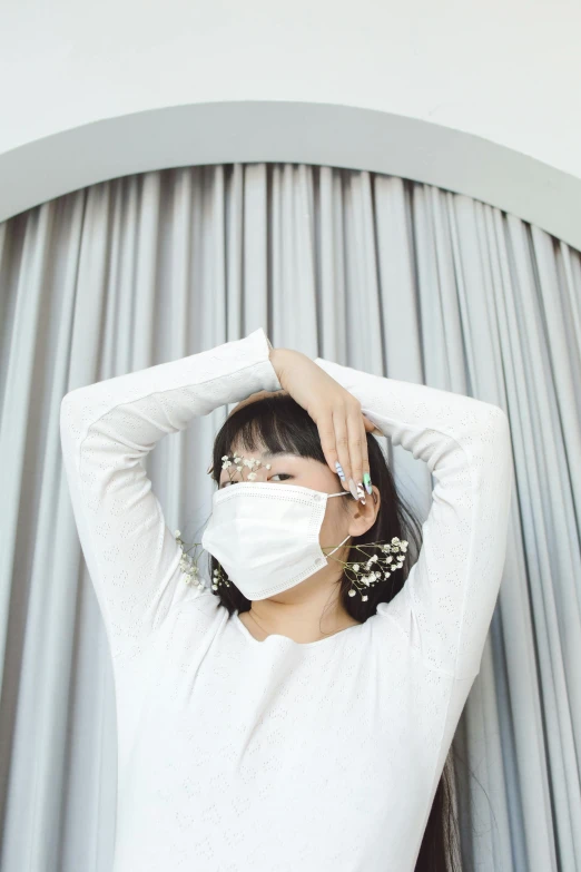 a woman in a white shirt and a face mask, by Oka Yasutomo, trending on pexels, curtain bangs, [ zero - gravity ]!!, clamp style, flowery