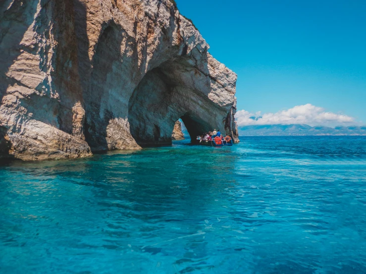 a group of people riding on top of a boat in the ocean, pexels contest winner, stone grotto in the center, greek pool, piroca, 1 2 9 7