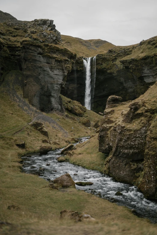 a man standing in front of a waterfall, icelandic valley, 8 k detail post - processing, seen from afar, f/1.4