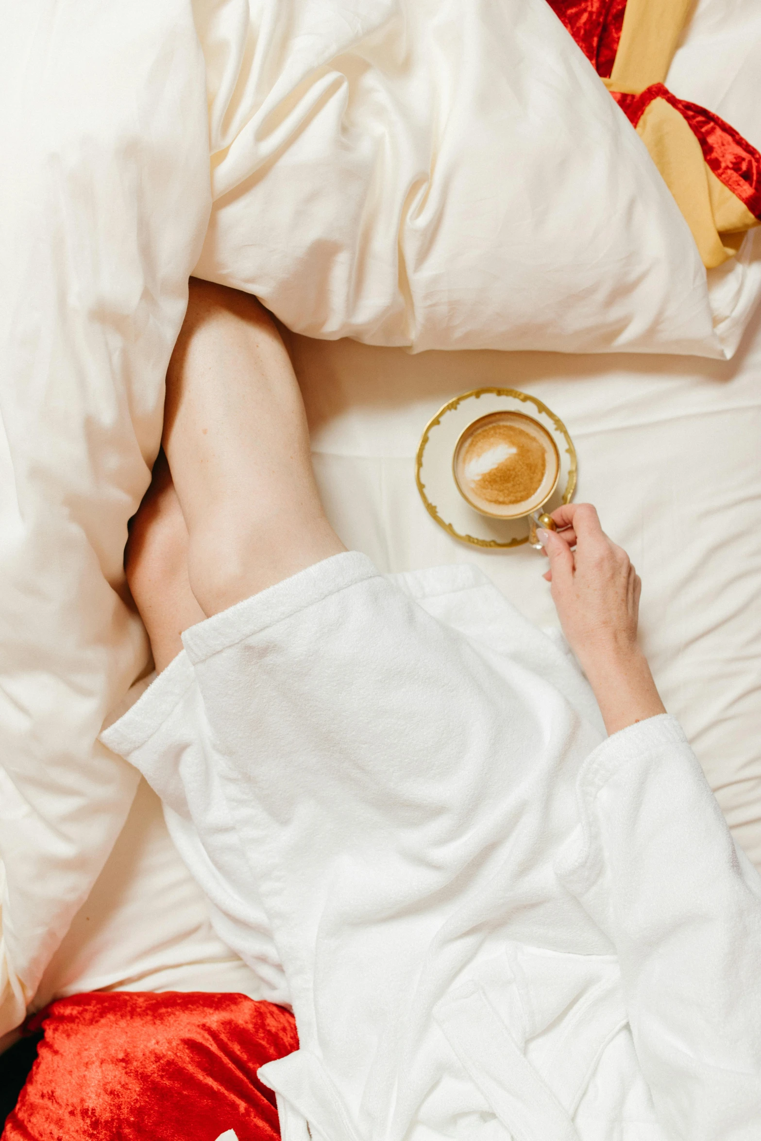 a woman laying in bed with a cup of coffee, trending on pexels, renaissance, legs intertwined, silk robes, pregnancy, gif