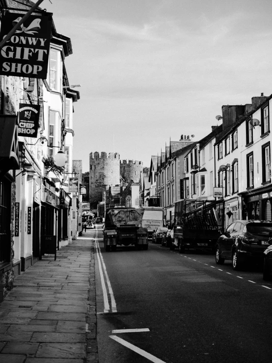 a black and white photo of a city street, by Kev Walker, caernarfon castle, taken from the high street, medieval coastal village, detailed medium format photo