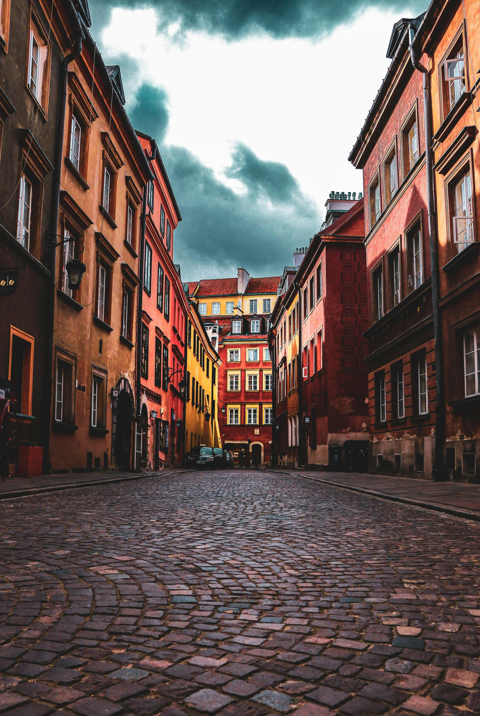 a cobblestone street in a european city, by Adam Marczyński, pexels contest winner, renaissance, colorful with red hues, square, empty buildings, ominous photo