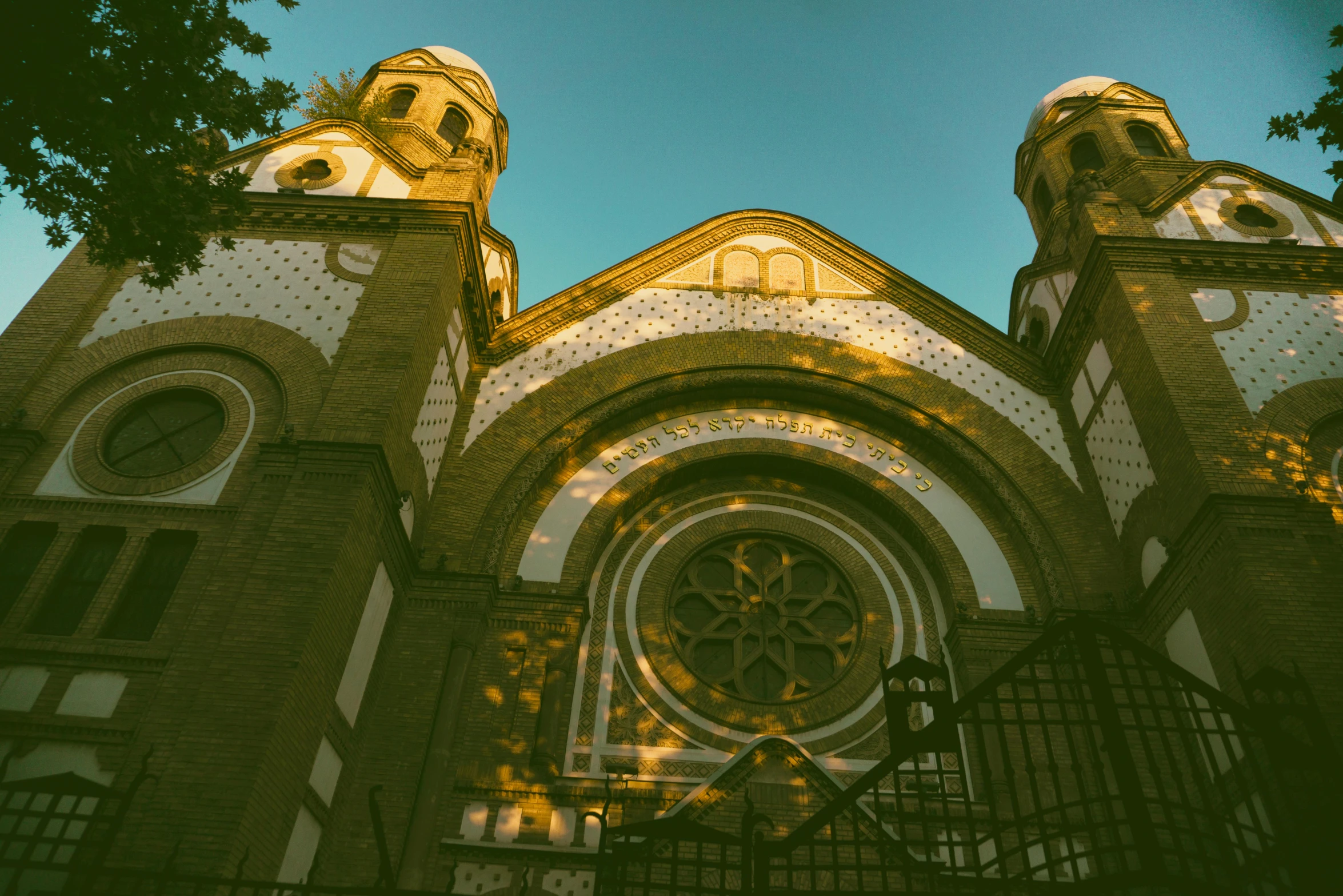 a church with a clock on the front of it, a picture, by Adam Marczyński, pexels contest winner, art nouveau, golden hues, kalighat, front view, viewed from the ground