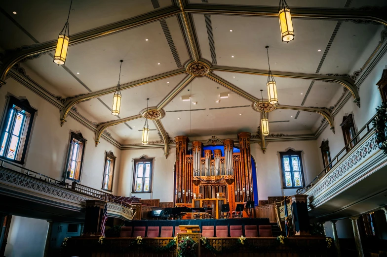 the interior of a church with stained glass windows, an album cover, inspired by Sydney Prior Hall, unsplash, happening, with large golden pipes, wide high angle view, masonic lodge, afternoon light