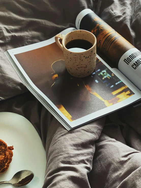 a plate of food and a cup of coffee on a bed, by Lucia Peka, pexels contest winner, photorealism, cover of a magazine, profile image, night photo, warm cosy colors