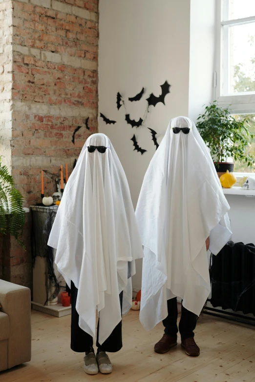 two people dressed as ghosts in a living room, graffiti, cardboard cutout, white, bats, trend