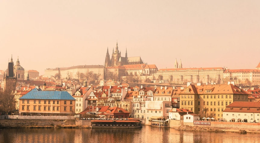 a view of a city from across a river, by Matija Jama, pexels contest winner, baroque, toned orange and pastel pink, prague, slide show, muted browns