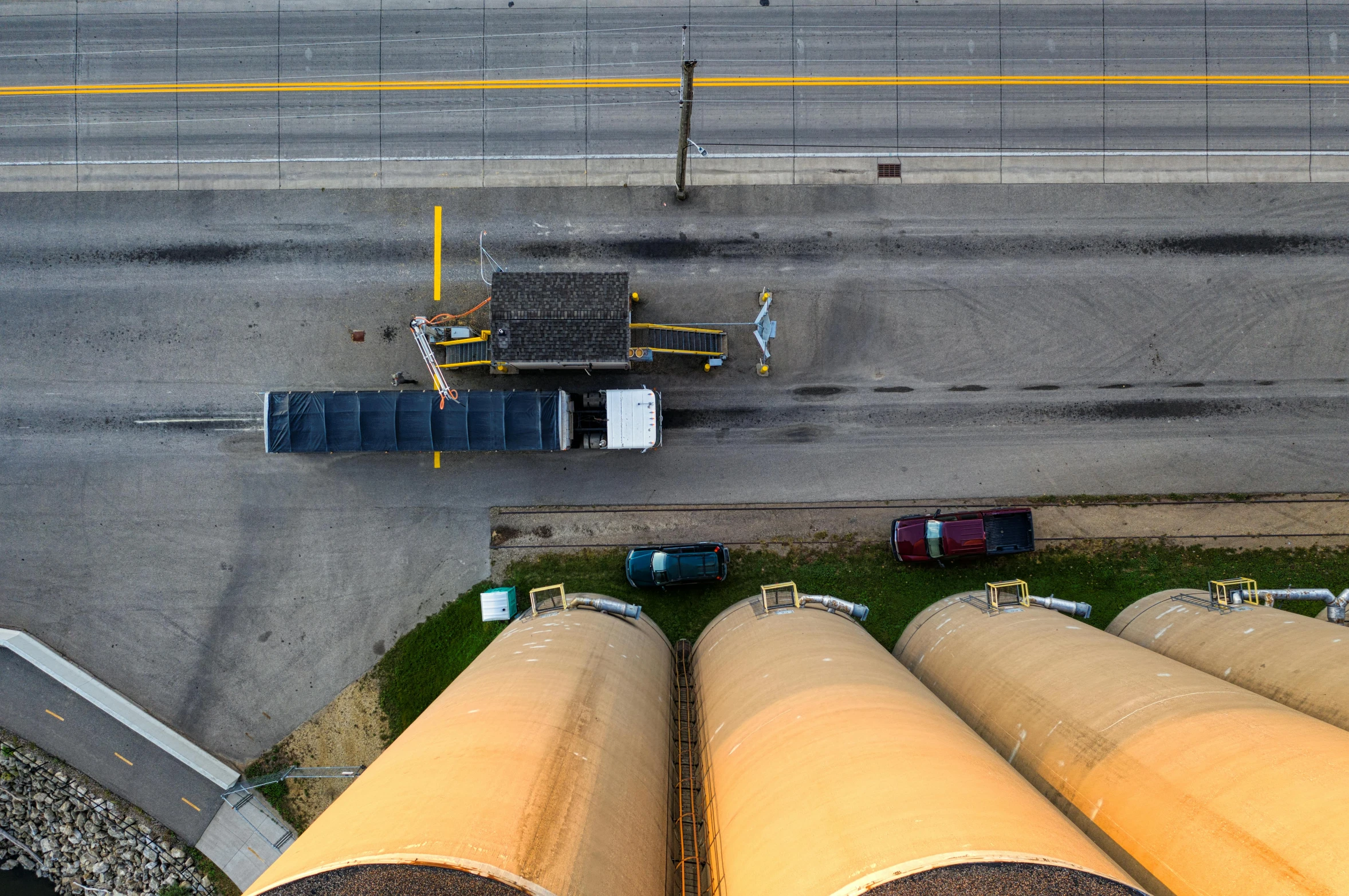 a group of pipes sitting next to each other on the side of a road, by Joe Stefanelli, pexels contest winner, photorealism, aerial view cinestill 800t 18mm, silo, high towers, propane tanks