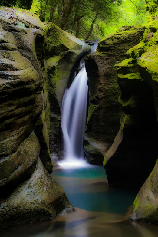 a small waterfall flowing through a lush green forest, a picture, unsplash contest winner, art nouveau, antelope canyon, smooth cave rock, paul barson, new zeeland