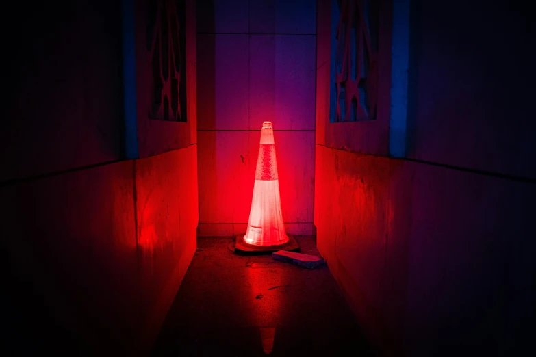 a red and white traffic cone in a dark room, inspired by Elsa Bleda, pink and blue lighting, akira yoshizawa, dark hallways, police lights