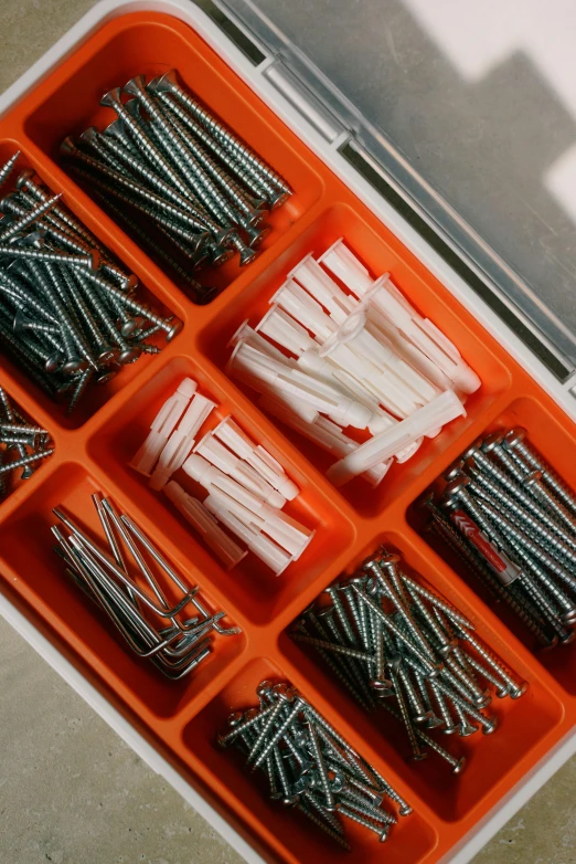 a box filled with lots of different types of screws, orange and white, thumbnail, striped