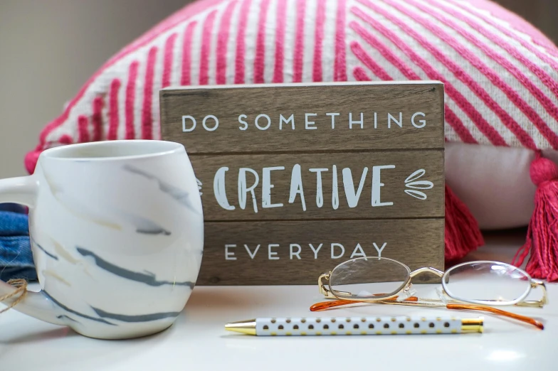 a wooden sign that says do something creative everyday, instagram, avatar image, square glasses, small and cosy student bedroom, white marble interior photograph
