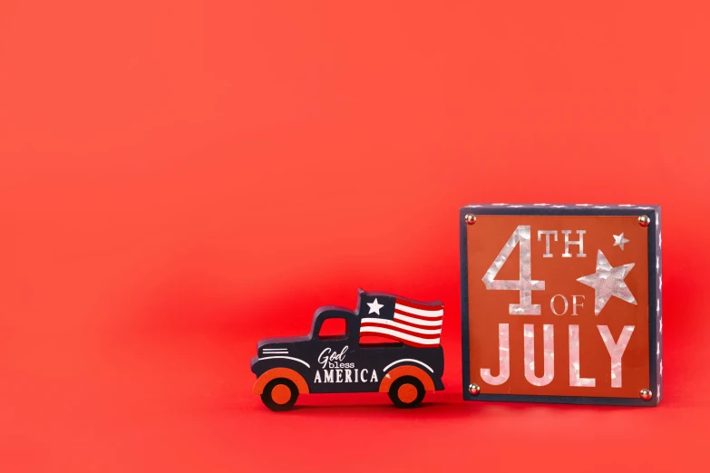 a toy truck sitting next to a sign that says 4th of july, by Julia Pishtar, red and black colour scheme, medium format, ad image, product shot