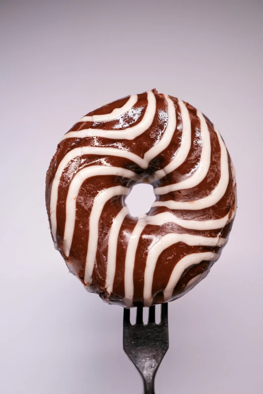 a chocolate donut with white icing on a fork, a marble sculpture, inspired by Joris van der Haagen, unsplash, striped, extremely detailed frontal angle, on clear background, brown:-2