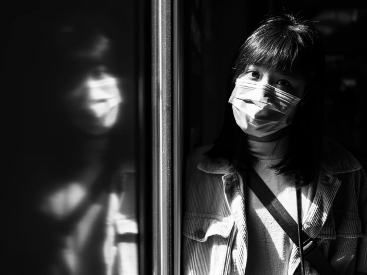 a black and white photo of a woman wearing a face mask, a black and white photo, shin hanga, window reflections, coronavirus, a young asian woman, teenage girl