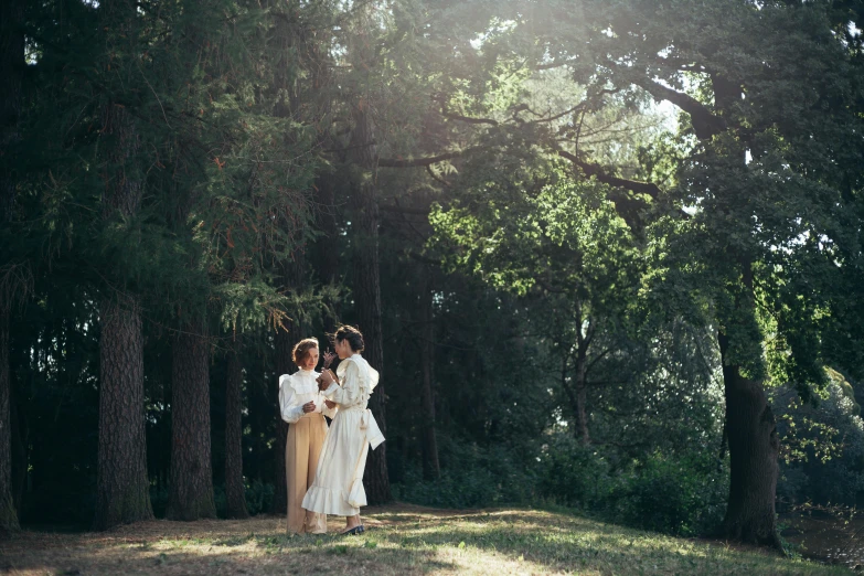 a couple of people that are standing in the grass, inspired by Konstantin Somov, unsplash, renaissance, pine forests, white robes, production still, sydney park