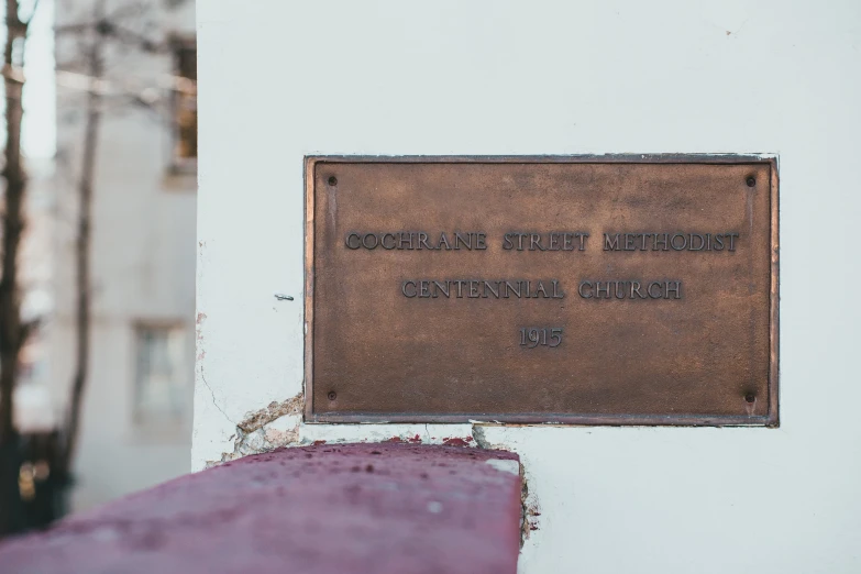 a plaque that is on the side of a building, an engraving, inspired by Constantine Andreou, cg society, cathedral background, confetti, benches, copper