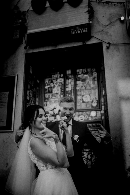 a black and white photo of a bride and groom, a black and white photo, by Alessandro Allori, happening, giving a thumbs up to the camera, standing in an alleyway, gif, actors