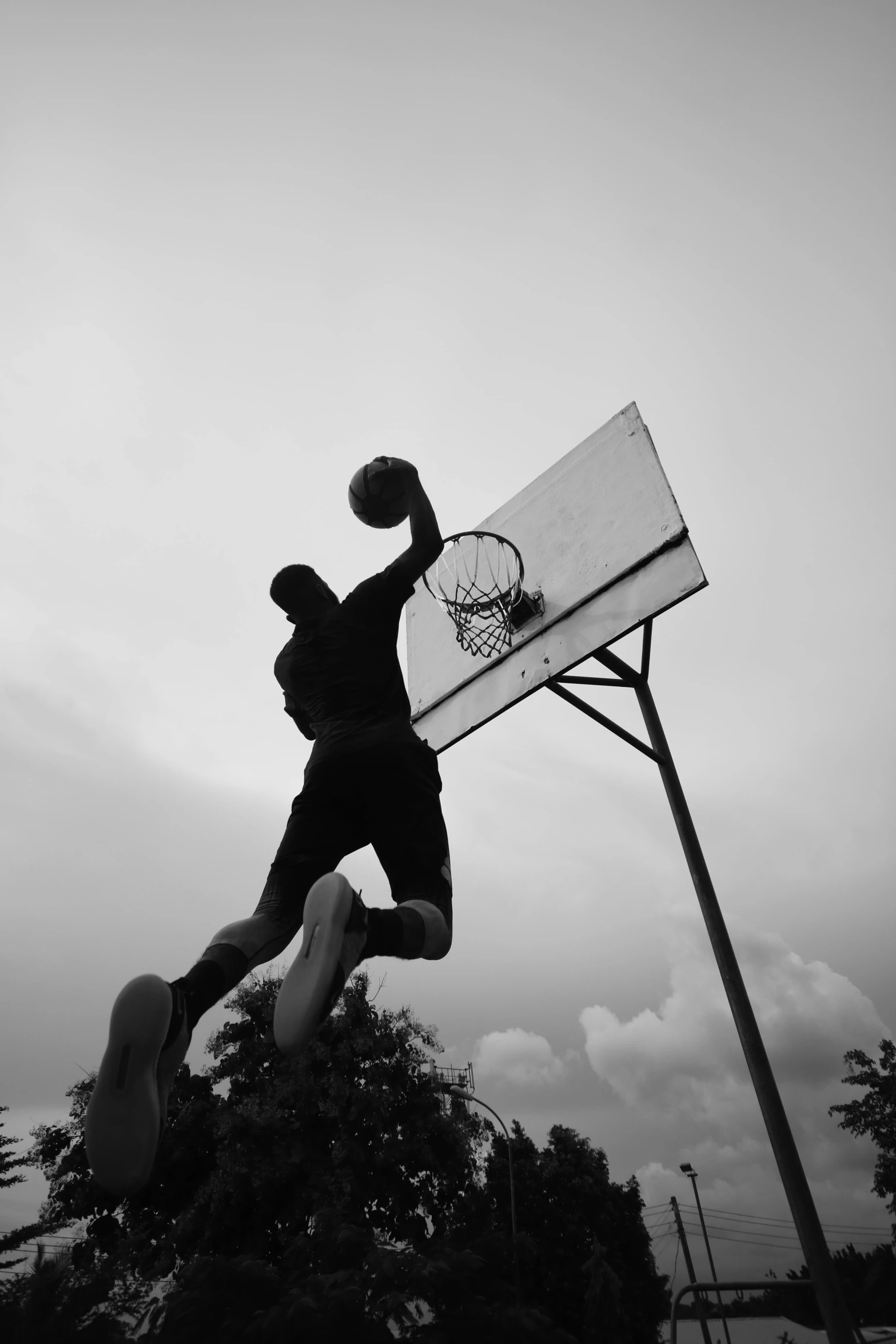 a man that is jumping in the air with a basketball, a black and white photo, unsplash contest winner, album cover art, early evening, in game, kano)