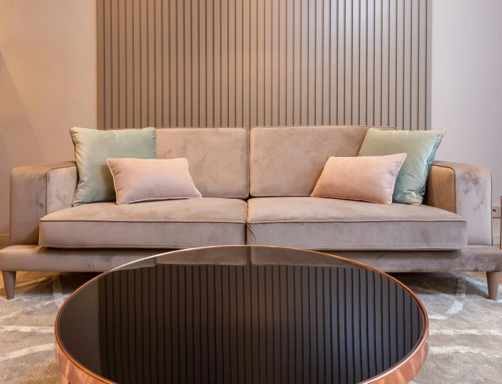 a living room with a couch and a coffee table, inspired by Constantin Hansen, pexels contest winner, art nouveau, copper details, taupe, panels, low - angle shot