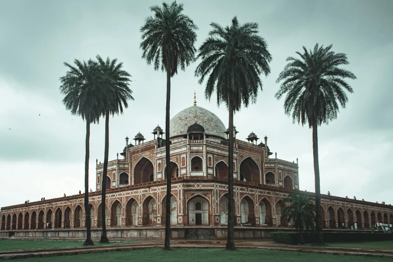 a large building surrounded by palm trees on a cloudy day, pexels contest winner, baroque, beautiful futuristic new delhi, tomb, with an intricate, archs