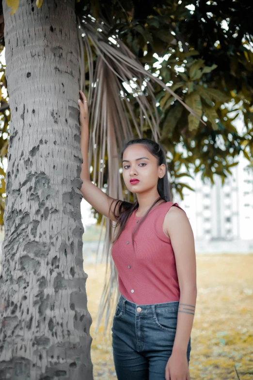 a woman standing next to a tree in a park, by reyna rochin, pexels contest winner, realism, handsome girl, indian girl with brown skin, in front of white back drop, modelling