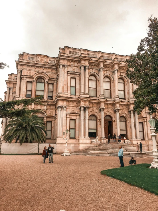 a group of people standing in front of a large building, a marble sculpture, inspired by Niyazi Selimoglu, pexels contest winner, huge mansion, square, view from the street, botanic garden