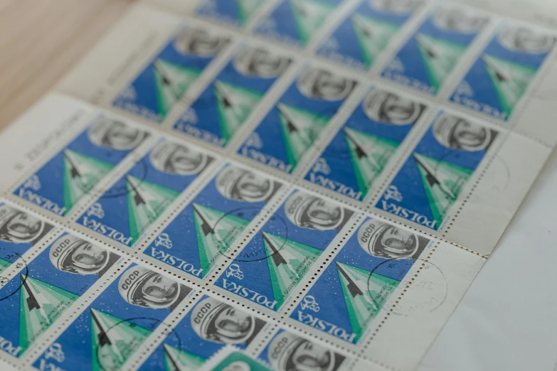 a close up of a sheet of stamps on a table, inspired by Doris Boulton-Maude, vostok-1, brand colours are green and blue, foster and partners, candid photograph