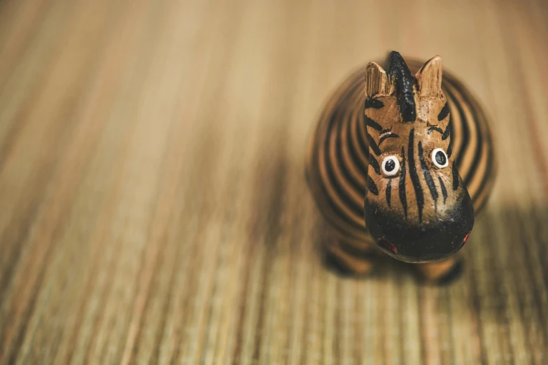 a zebra figurine sitting on top of a wooden floor, by Adam Marczyński, unsplash, folk art, totoro from my neighbor totoro, made of bamboo, brown, squishy