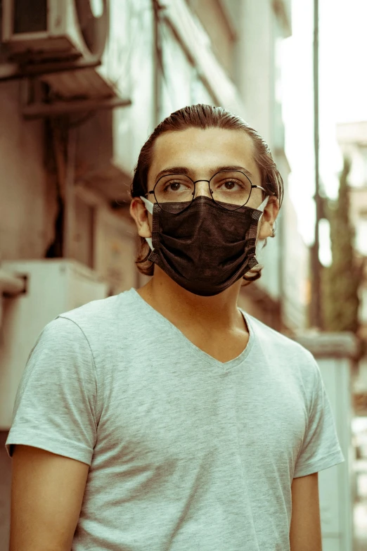 a man wearing a face mask on a city street, an album cover, pexels contest winner, renaissance, wearing black glasses, headshot profile picture, egypt, lgbtq