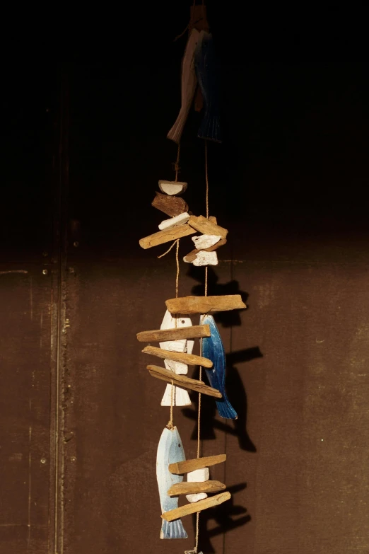 a close up of a wind chime on a pole, an album cover, by Paul Bird, with a wooden stuff, an indigo bunting, demur, wabi sabi